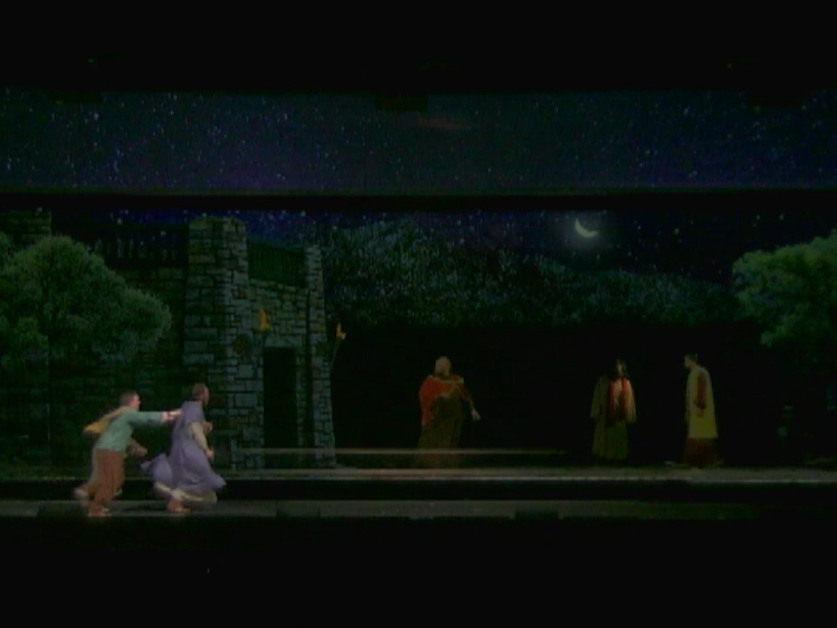 a couple of people that are standing in the dark